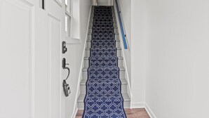 A staircase with a patterned carpet, white walls, and a door with a number '1' above it. - Cozy 2 Bedroom with a view with WiFi, AC (Seaside Heights)