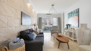 A modern living room with a sofa, coffee table, and a view of the outdoors. - Private Villa with Heated Pool, Air Conditioning, and Football Field (Candelaria)