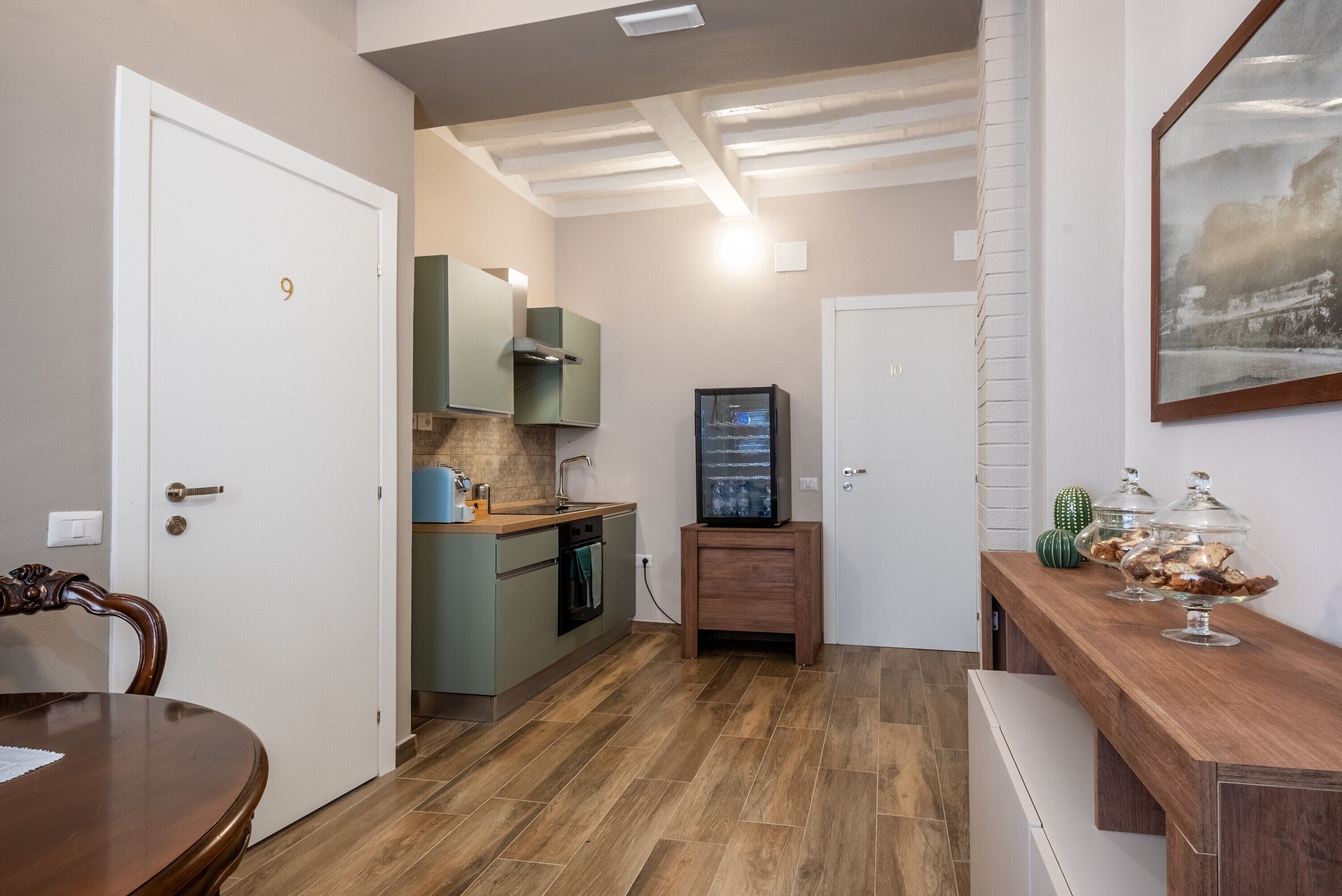 A compact kitchen with a dining table, a built-in oven, and a television.