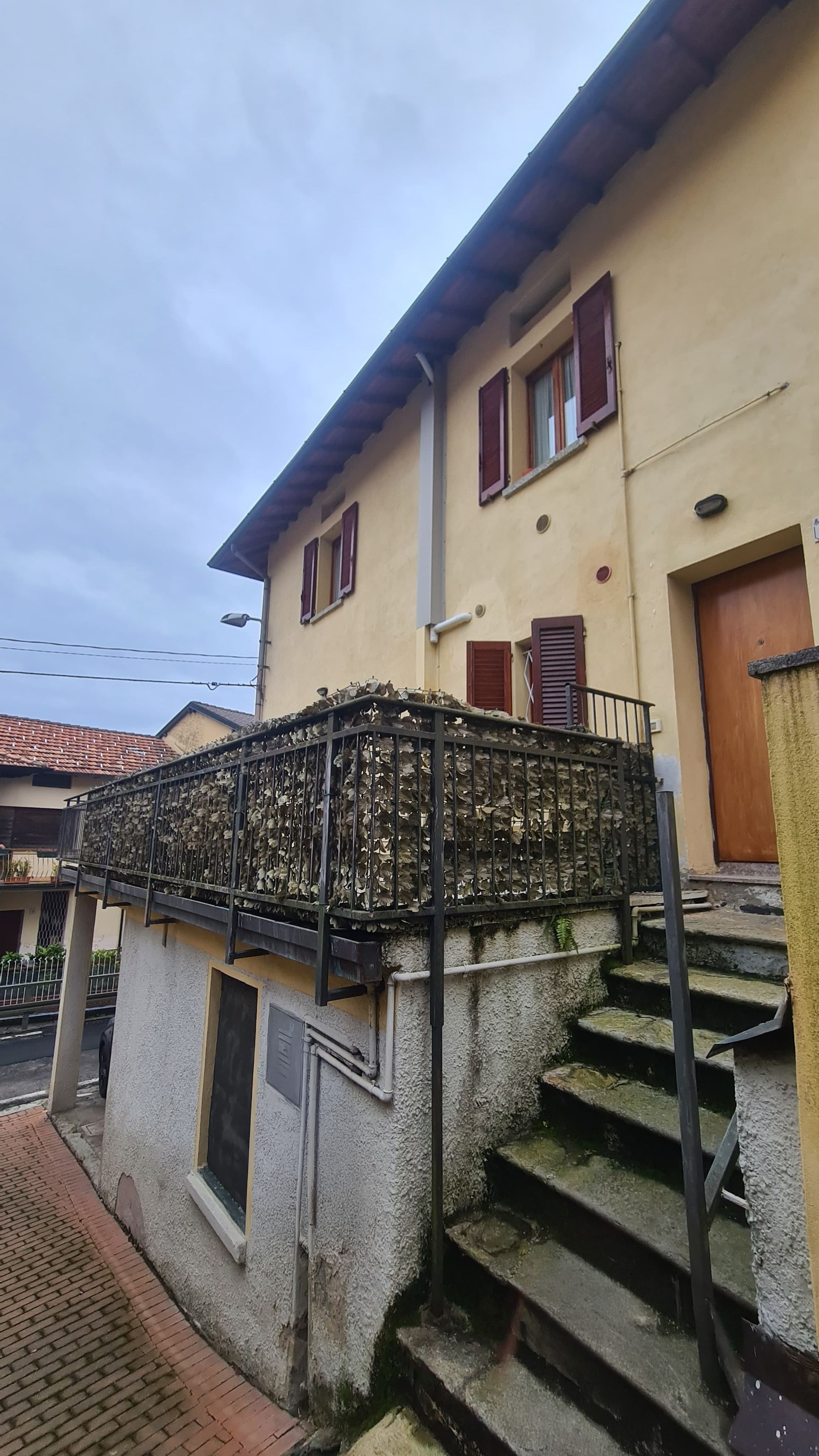 A building with a staircase, a metal railing, and a door.