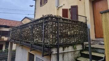 A building with a staircase, a metal railing, and a door.