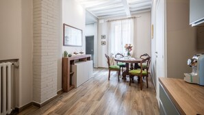 Un comedor con pared de ladrillo, mesa de madera y sillas.