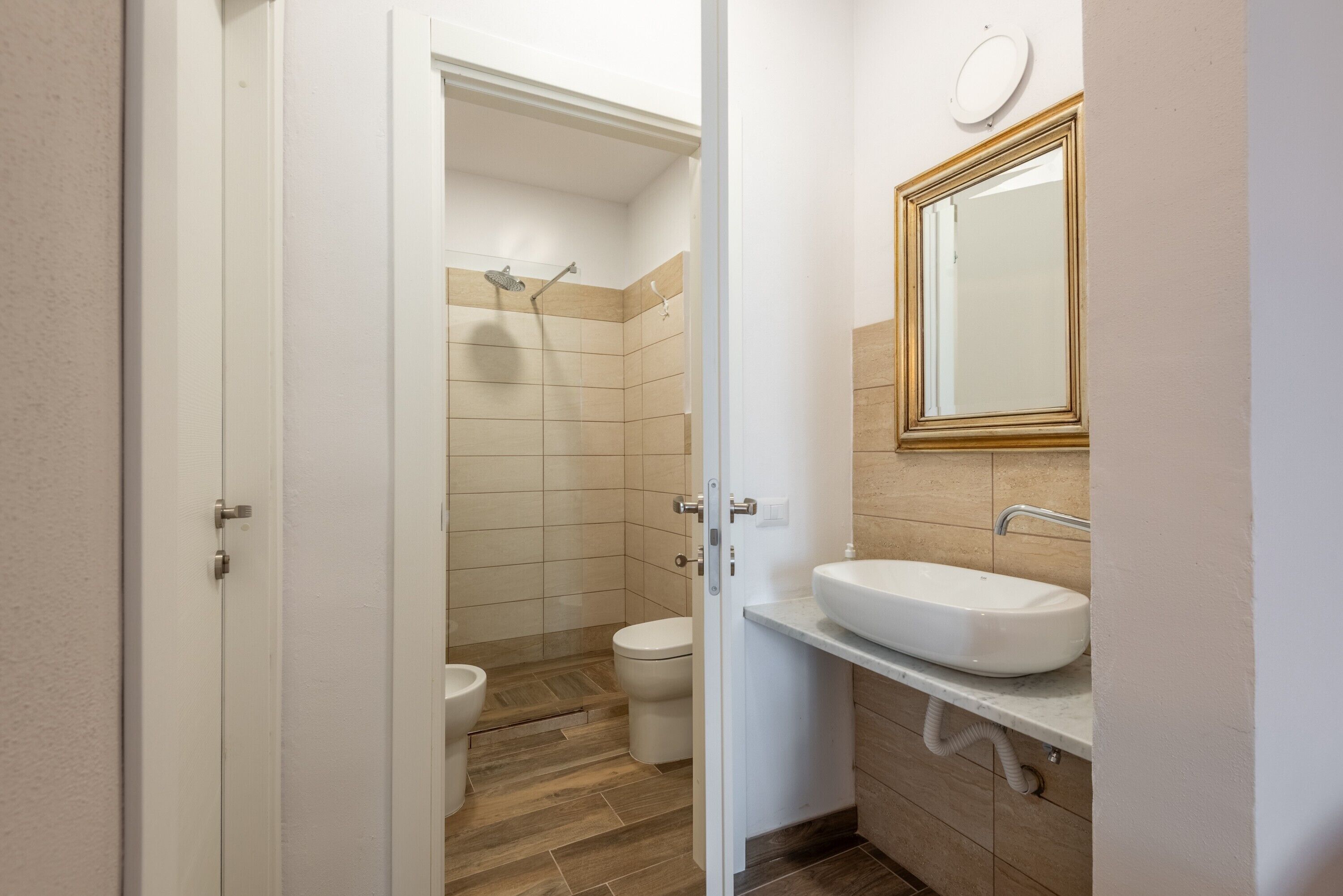A bathroom with a toilet, shower, and sink.