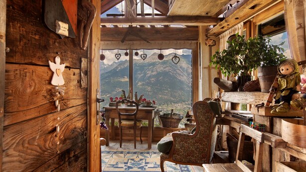 A rustic wooden interior with a mountain view, a dining area, and a cozy seating arrangement. - Room 'Camoscio' – Space and Comfort with Balcony and Alpine Views (Charvensod)