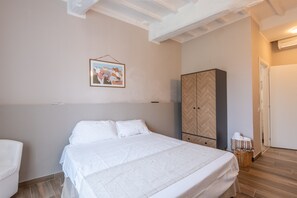 Una camera da letto con un letto, un armadio, un quadro appeso al muro e una porta.