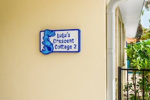 En skylt med texten ”LuLu’s Crescent Cottage 2” är monterad på en vägg.