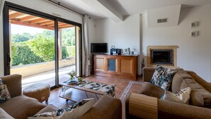 Ein großzügiger Wohnbereich mit einer Couch, einem Couchtisch, einem Fernseher und einem Kamin.