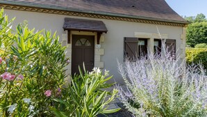 Un bâtiment doté d’un toit en pente, d’une porte surmontée d’une fenêtre et d’une petite fenêtre à l’étage supérieur.