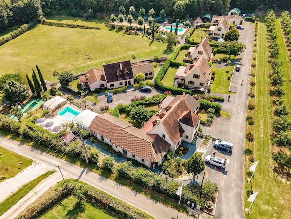 A residential area with houses, a swimming pool, and a tennis court.