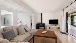 A modern living room with a sofa, a coffee table, a fireplace, and a television. - Villa 'V206  Isabel' with Sea View, Wi-Fi and Air Conditioning (San Jaime Mediterráneo)