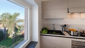 A modern kitchen with a large window, a sink, and a stove.