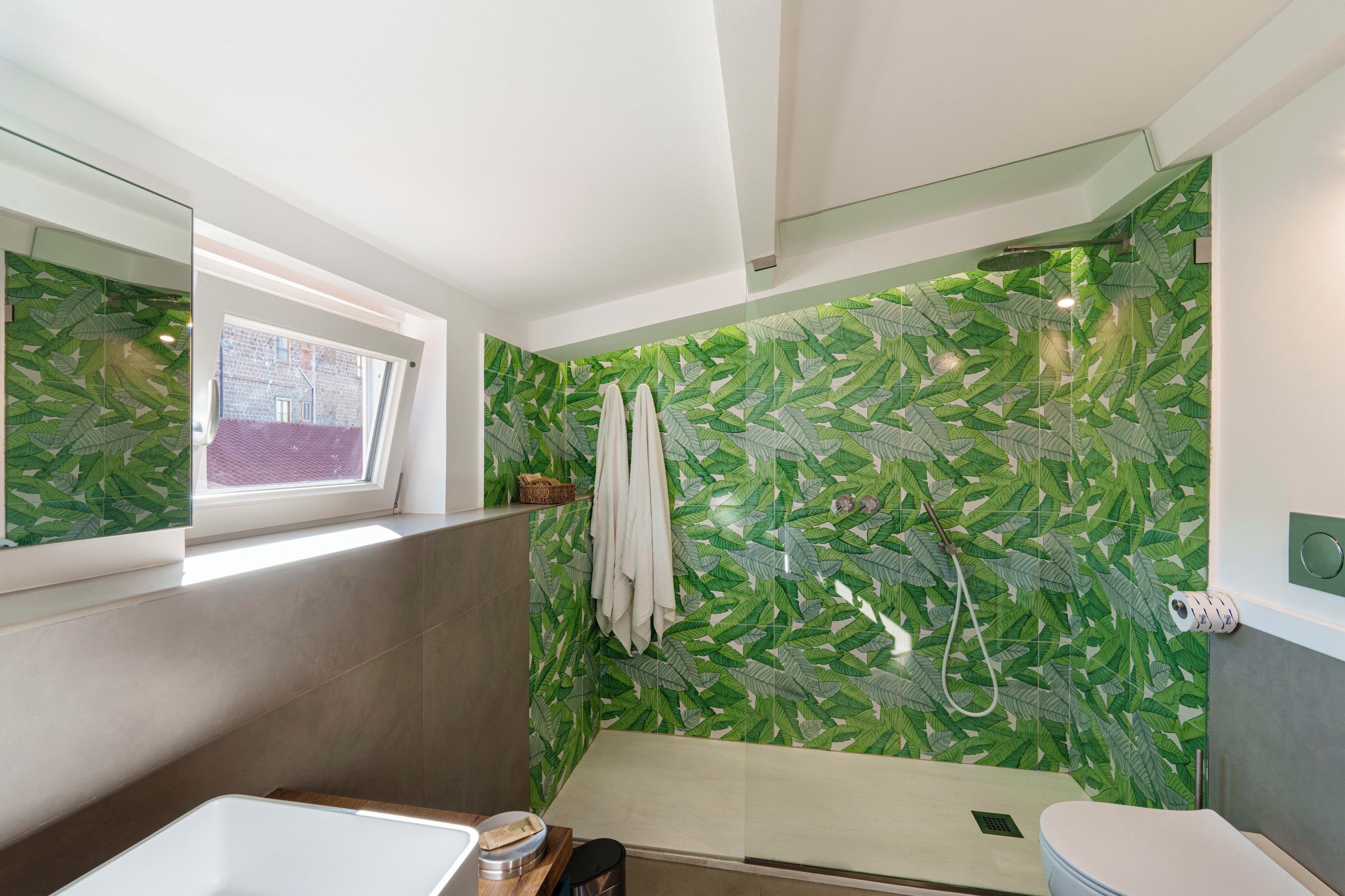 A modern bathroom with a shower, toilet, and sink.