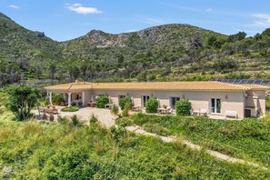 A house with a patio, surrounded by greenery and mountains. - Room 'Menta' with Mountain View, Wi-Fi and Air Conditioning (L'Atzúbia)