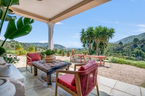 An outdoor patio with a table, chairs, and a view of the hills. - Room 'Menta' with Mountain View, Wi-Fi and Air Conditioning (L'Atzúbia)