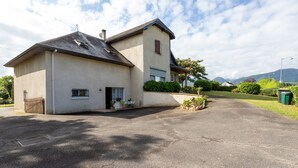 Une maison à deux étages avec une allée menant à l’entrée.