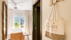 Une chambre d’hôtel avec un lit, une table et une vue sur la verdure.