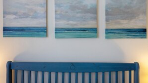 Three paintings of the ocean on a wall.