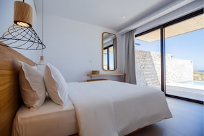 Une chambre à coucher moderne avec un lit, une table de chevet et une grande fenêtre.