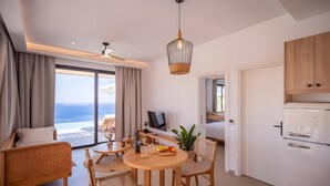 Een moderne woonkamer met een eethoek, een televisie en uitzicht op de oceaan.
