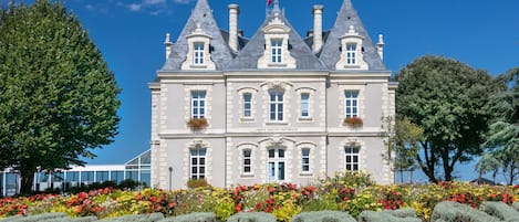 A historic building with a symmetrical facade, multiple chimneys, and a central entrance.