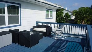 Una terraza con mobiliario exterior, incluyendo un sofá y sillas, y una piscina.