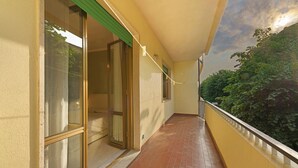 A corridor with a tiled floor, glass doors, and a yellow wall. - Apartment 'Casa Nonna Adri' with Shared Terrace and Wi-Fi (levanto)
