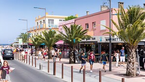 A busy street with pedestrians, palm trees, and buildings with shops. - Mobile Home Caravan with Shared Pool and Private Terrace (Unknown)