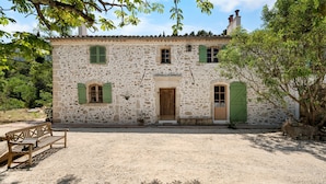 A stone building with a wooden door, green shutters, and a bench in front. - Samadhi Holiday Home with Mountain Views, Wi-Fi, and Air Conditioning (Toulon)
