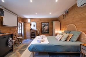 Ein Zimmer aus Holz mit einem Bett, einem Schreibtisch und einem Stuhl.
