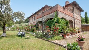 A historic building with stone arches, a garden with potted plants, and outdoor seating. - Apartment 'Il Magnifico' with Shared Pool, Private Terrace and Wi-Fi (Unknown)