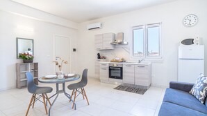 Une cuisine moderne équipée d’un four à micro-ondes, d’un four traditionnel et d’une fenêtre. On y trouve également un coin repas avec une table et des chaises.