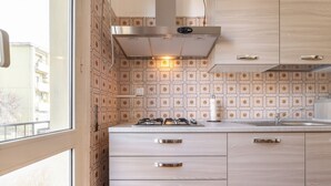 Une cuisine moderne dotée d’une cuisinière à gaz, de meubles en acier inoxydable et d’un dosseret décoratif.