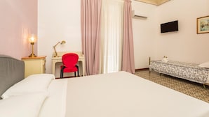 A hotel room with a large bed, a desk with a chair, a television, and a small bedside table. - Room 'Ds - Camera Tripla' with Shared Terrace, Wi-Fi and Air Conditioning (Catania)