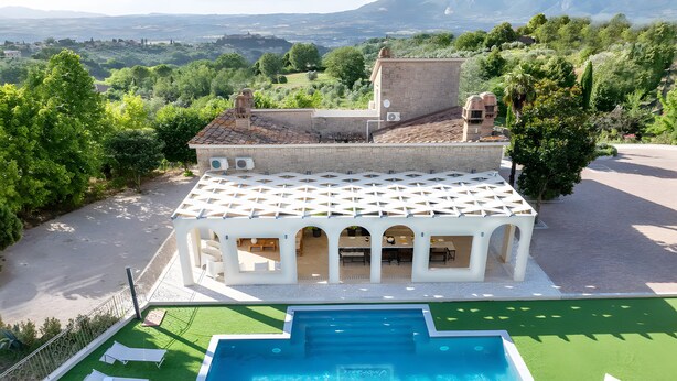 A villa with a swimming pool, outdoor seating, and a view of the surrounding landscape. - Holiday Home 'Appartamento in Villa Umbriace' with Shared Pool, Wi-Fi and Air Conditioning (Stroncone)