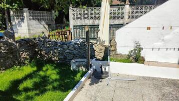 A stone wall, a white fence with decorative patterns, and a grassy area.