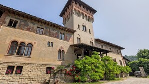 Un bâtiment historique doté d’une tour, de murs en pierre et d’un porche abrité.