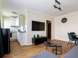 Cozy living space with a kitchen area, seating area, and flat-screen TV.