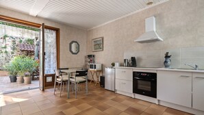 Una cocina compacta con comedor, microondas, cafetera y lavamanos.