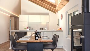 Una cocina moderna con techo de madera, una isla central con asientos y un horno empotrado.