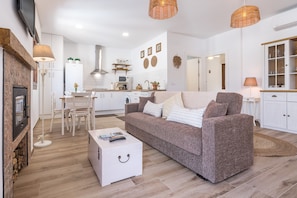 A modern living room with a sofa, coffee table, and a fireplace. - Apartment 'El Santo' with Mountain View, Wi-Fi and Air Conditioning (Melegis)