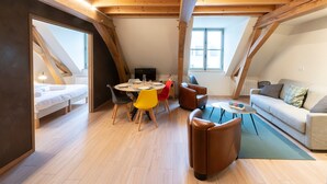 Une pièce de style loft comprenant un coin repas, un canapé et un lit.