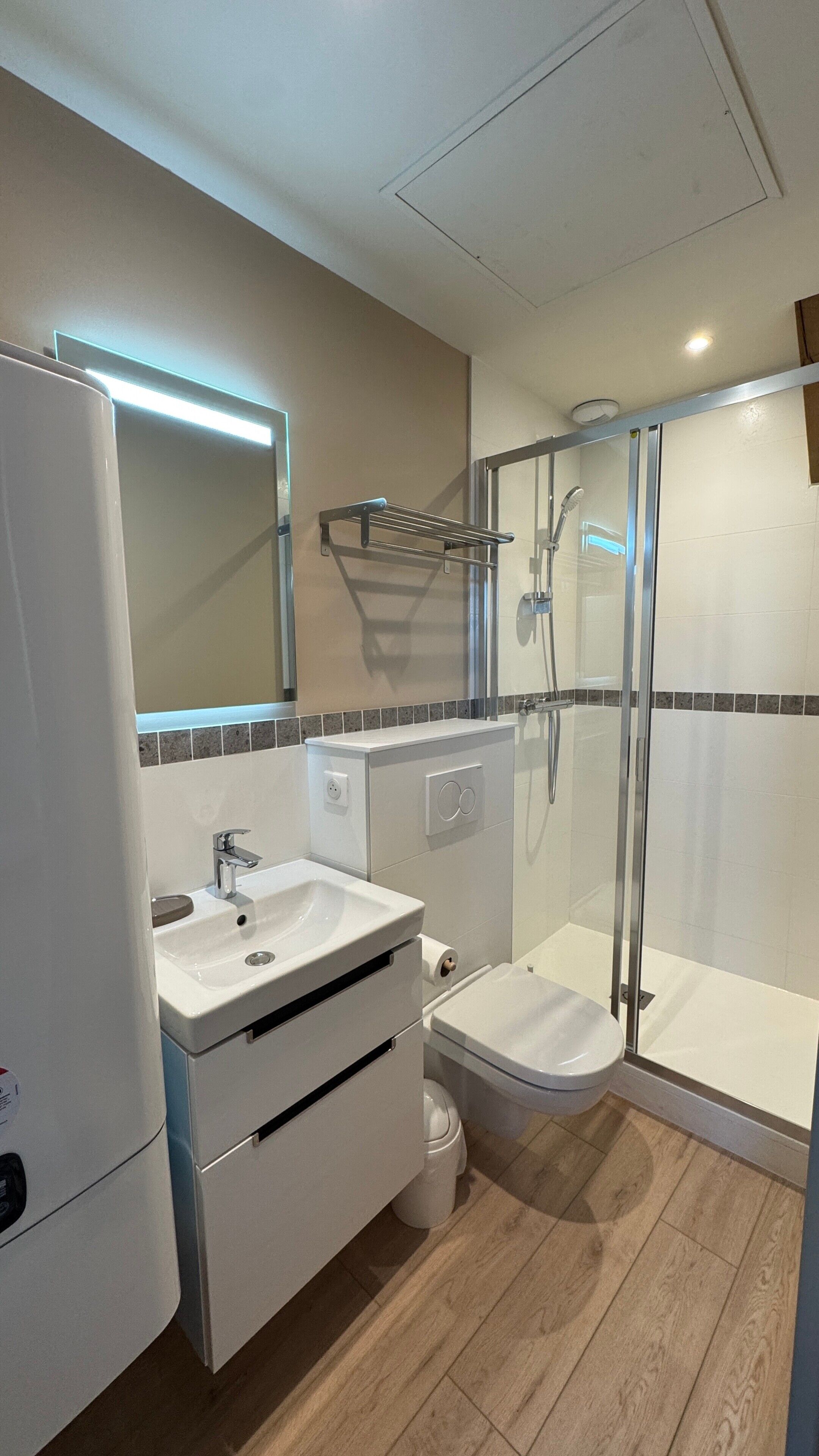 A modern bathroom with a sink, toilet, and shower.