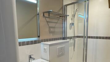 A modern bathroom with a sink, toilet, and shower.