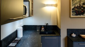A modern kitchen with a built-in microwave, a sink, and a countertop with a bottle of hand soap. - Apartment '7 - Seigneurie Fouquet' with Wi-Fi (Le Palais)