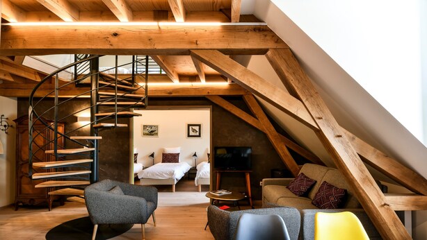 A loft-style room with a spiral staircase, a bed, a TV, and a sofa. - Apartment '7 - Seigneurie Fouquet' with Wi-Fi (Le Palais)