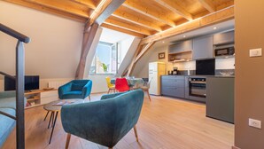 A loft-style apartment with a dining area, kitchen, and a large window. - Apartment 'Seigneurie Fouquet - Tousquet' with Wi-Fi (Le Palais)