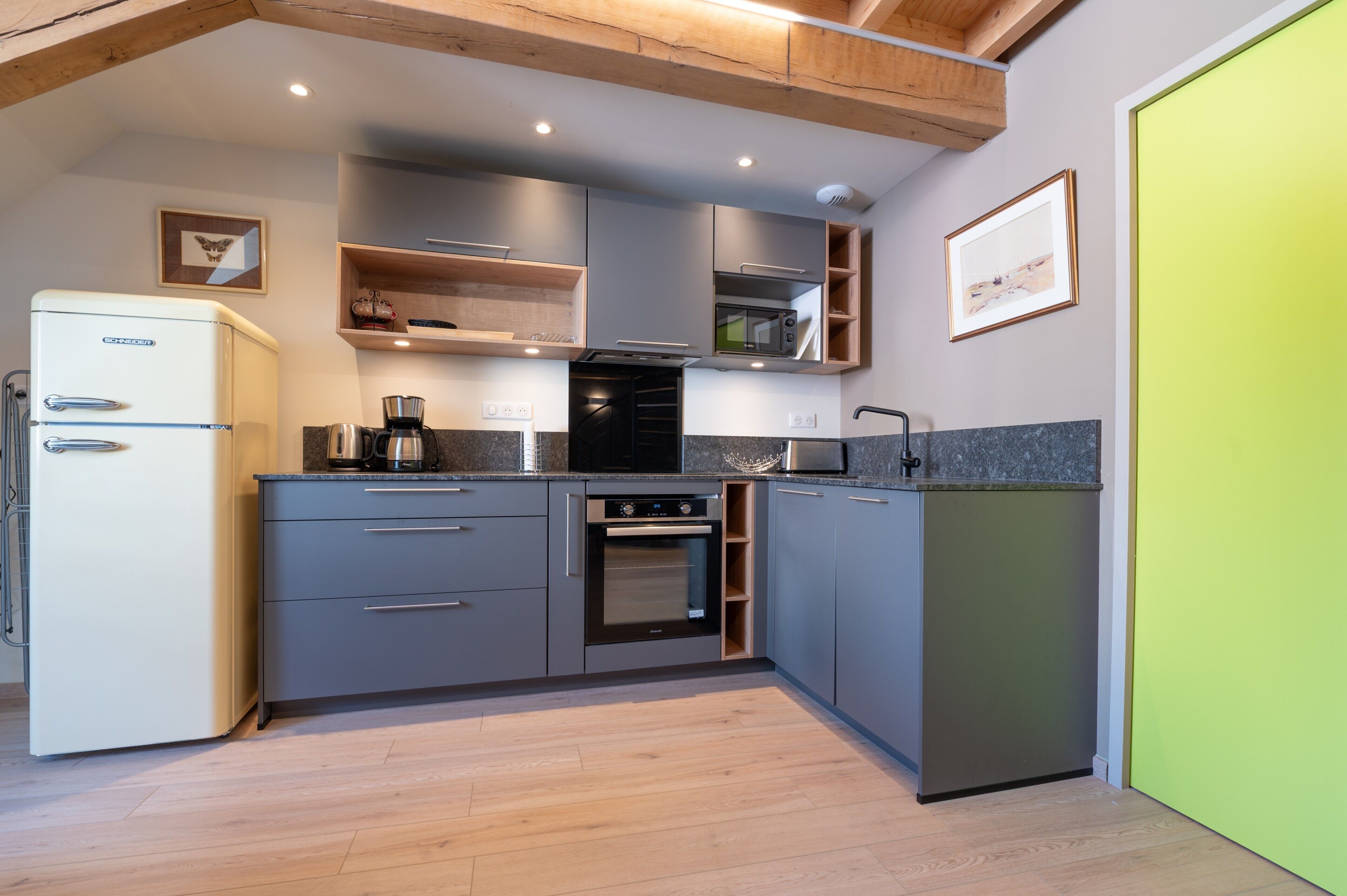 A compact kitchen with a built-in oven, a coffee maker, and a microwave.