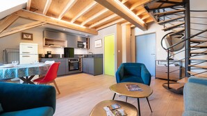 A modern interior with a dining area, kitchen, and a spiral staircase. - Apartment 'Seigneurie Fouquet - Tousquet' with Wi-Fi (Le Palais)