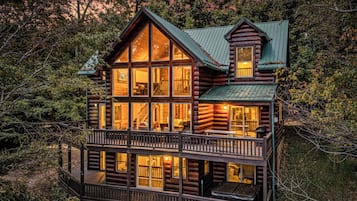 A log cabin with multiple windows, a balcony, and a small attached structure.
