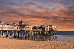 A pier with buildings, including a structure with an ATM sign and a Samuel Adams sign.